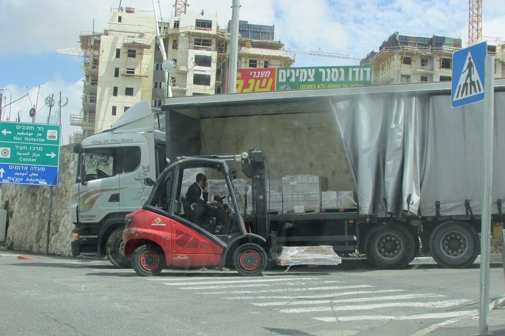 Carretilla elevadora Linde junto a un camión en una zona de carga del almacén