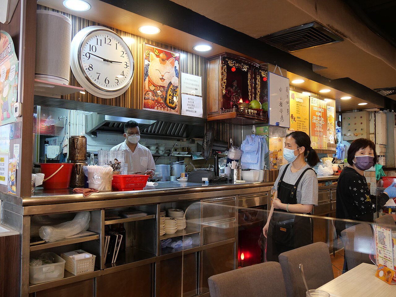 Cocinero y camareras trabajando en una cocina abierta