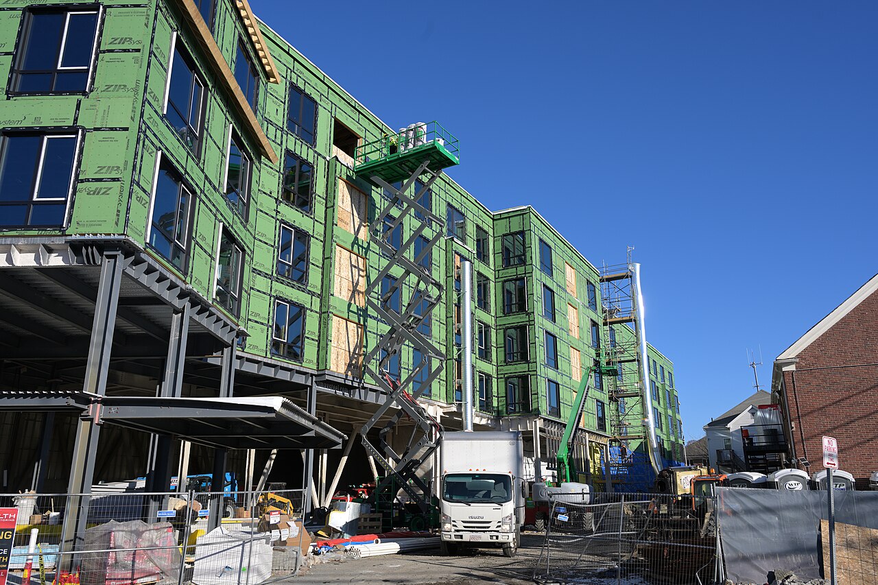 Plataforma de tijera elevada en la fachada de un edificio en construcción