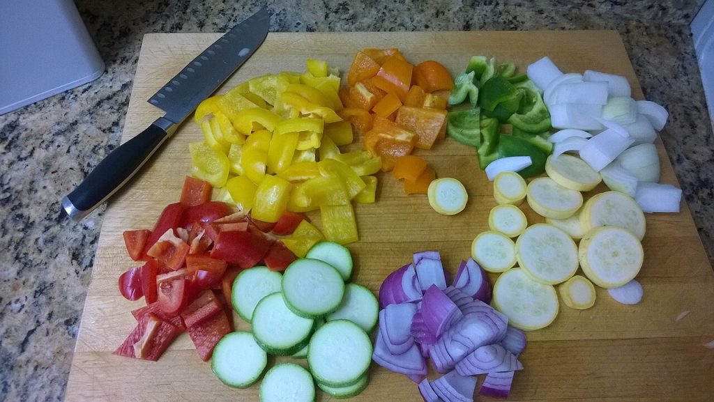 Verduras troceadas y cuchillo sobre una tabla de cortar